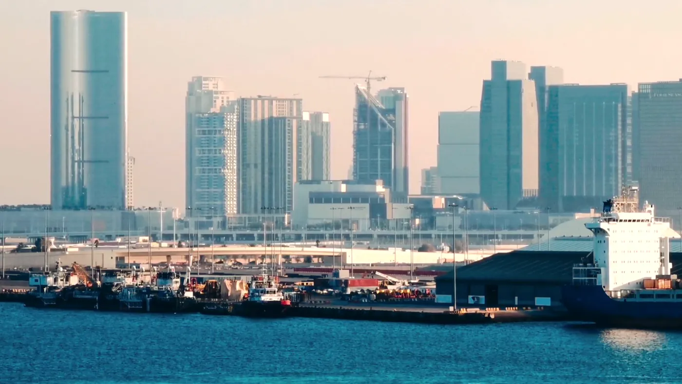 A working quay with a cargo ship alongside and towers behind
